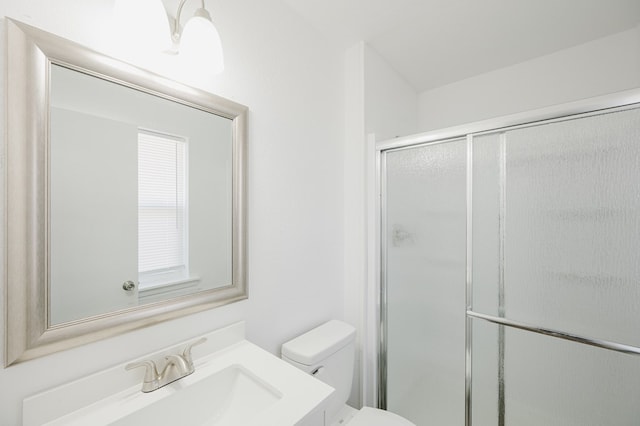 bathroom with toilet, a shower stall, and vanity