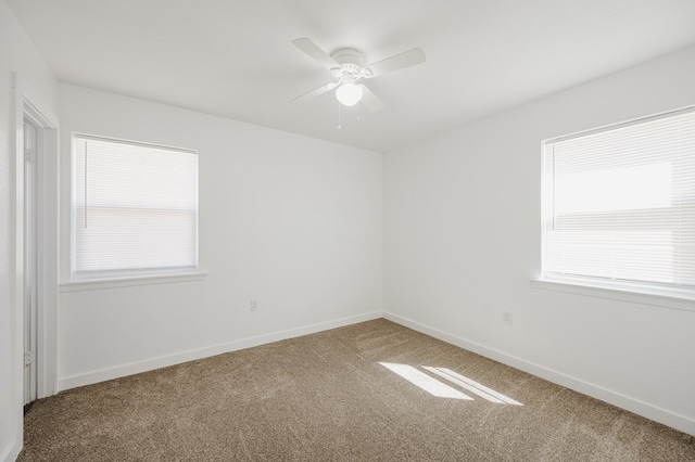 spare room featuring a ceiling fan, carpet flooring, and baseboards