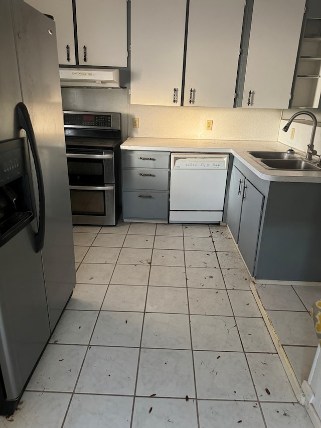 kitchen featuring gray cabinetry, light tile patterned floors, sink, and appliances with stainless steel finishes