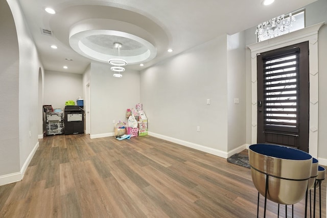 playroom with wood-type flooring and a raised ceiling