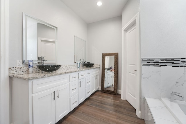 bathroom with a bathing tub, vanity, and hardwood / wood-style flooring