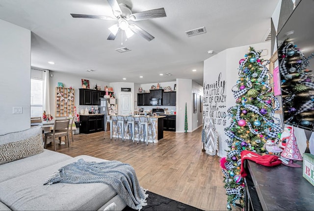 living room featuring ceiling fan and light hardwood / wood-style floors