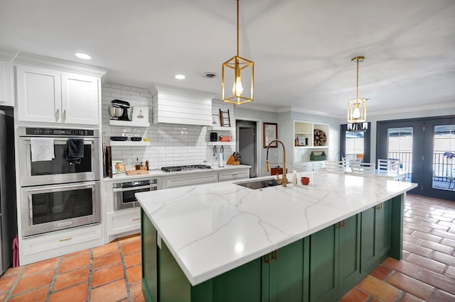 kitchen with stainless steel appliances, white cabinetry, and hanging light fixtures