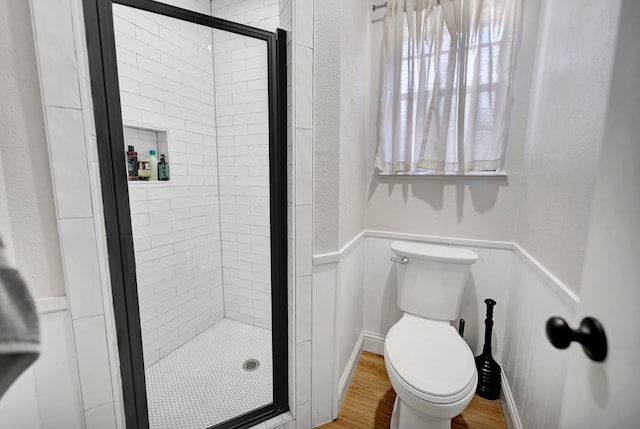 bathroom featuring wood-type flooring, an enclosed shower, and toilet