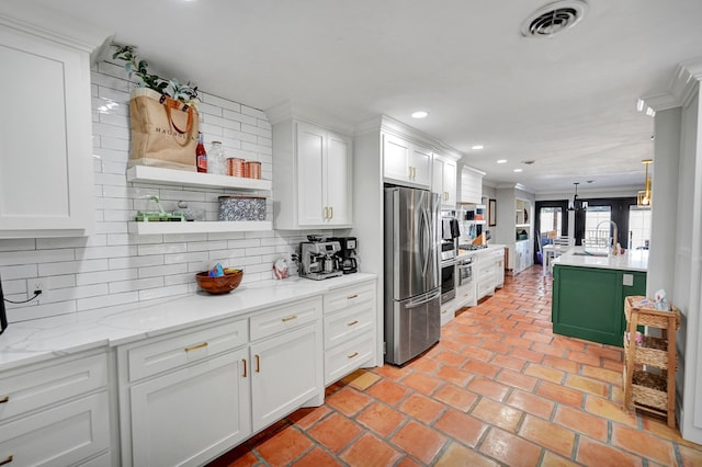 kitchen featuring white cabinets, sink, ornamental molding, appliances with stainless steel finishes, and tasteful backsplash