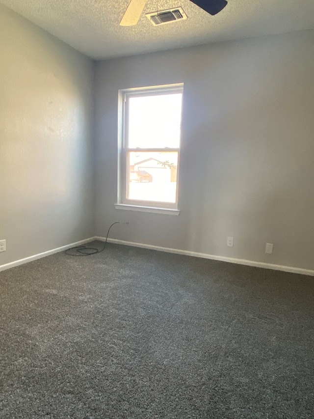 empty room featuring carpet floors, visible vents, baseboards, and ceiling fan