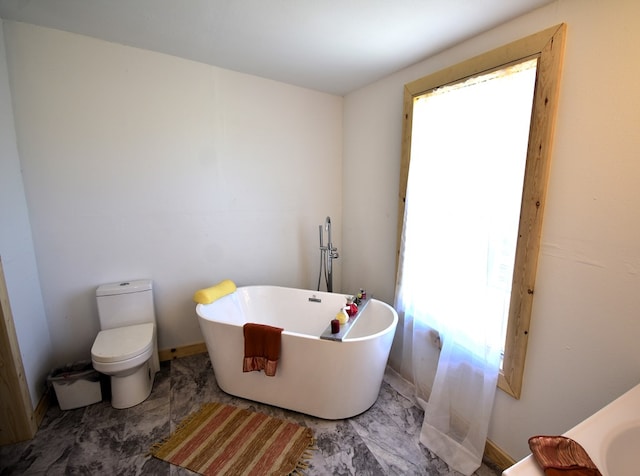 bathroom with a washtub and toilet