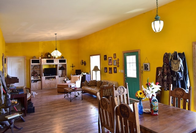 dining space featuring hardwood / wood-style floors and vaulted ceiling