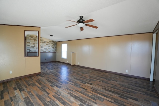 spare room featuring vaulted ceiling, dark hardwood / wood-style floors, ceiling fan, crown molding, and a textured ceiling