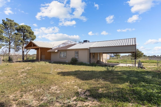 back of house featuring a carport and a yard