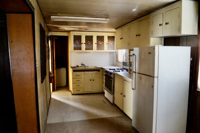 kitchen featuring cream cabinetry, white appliances, and sink