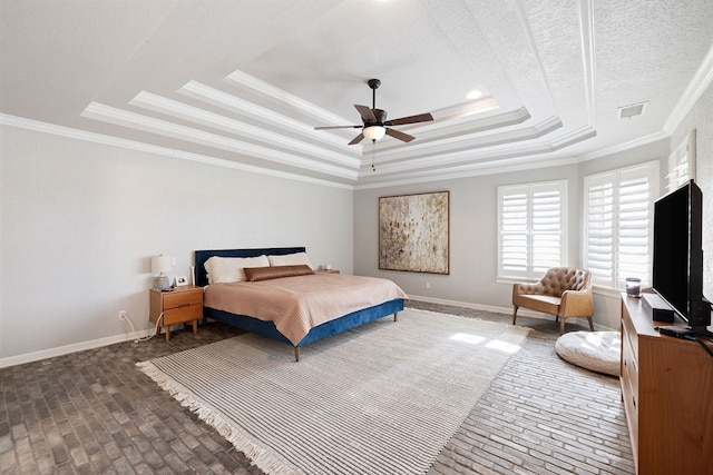 bedroom with visible vents, baseboards, and a tray ceiling