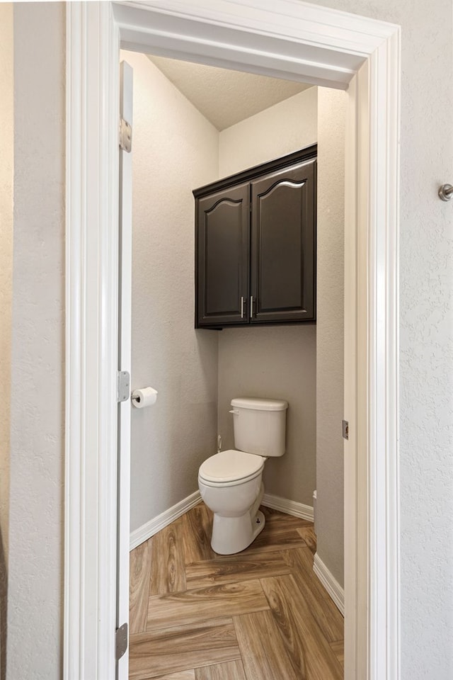 bathroom with toilet and baseboards