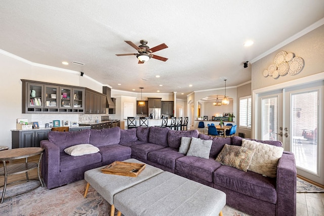 living area with a textured ceiling, crown molding, recessed lighting, and ceiling fan