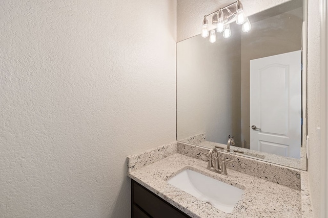 bathroom with vanity and a textured wall