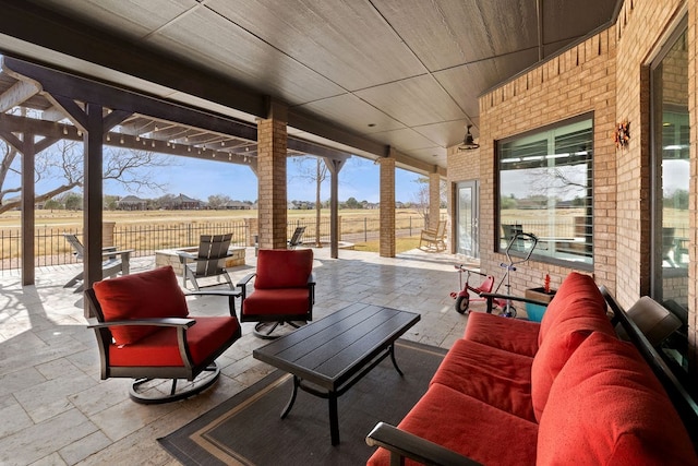 view of patio / terrace with an outdoor living space, a rural view, and fence