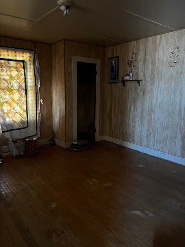 unfurnished room featuring hardwood / wood-style flooring and wood walls