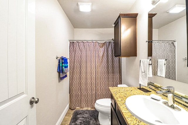 bathroom with vanity, curtained shower, and toilet