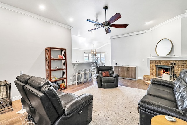 living room with ornamental molding, a fireplace, and light hardwood / wood-style flooring