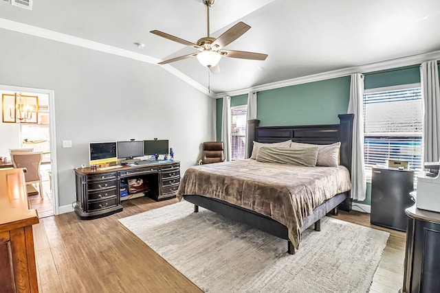 bedroom featuring multiple windows, wood-type flooring, ornamental molding, and lofted ceiling