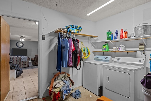 laundry area with light tile patterned floors, a textured ceiling, and washer and clothes dryer