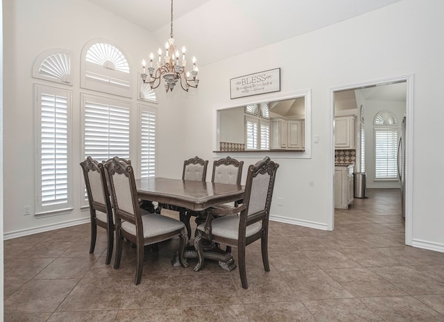 tiled dining space featuring an inviting chandelier, lofted ceiling, and plenty of natural light