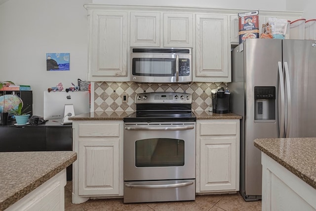 kitchen featuring stainless steel appliances, white cabinetry, light tile patterned flooring, and backsplash