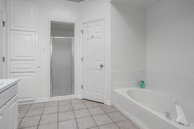 bathroom featuring tile patterned flooring, vanity, and plus walk in shower