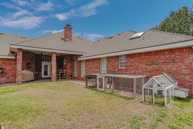 back of house with a yard and an outdoor structure