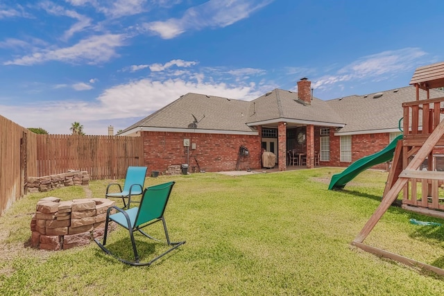 view of yard featuring a playground and an outdoor fire pit