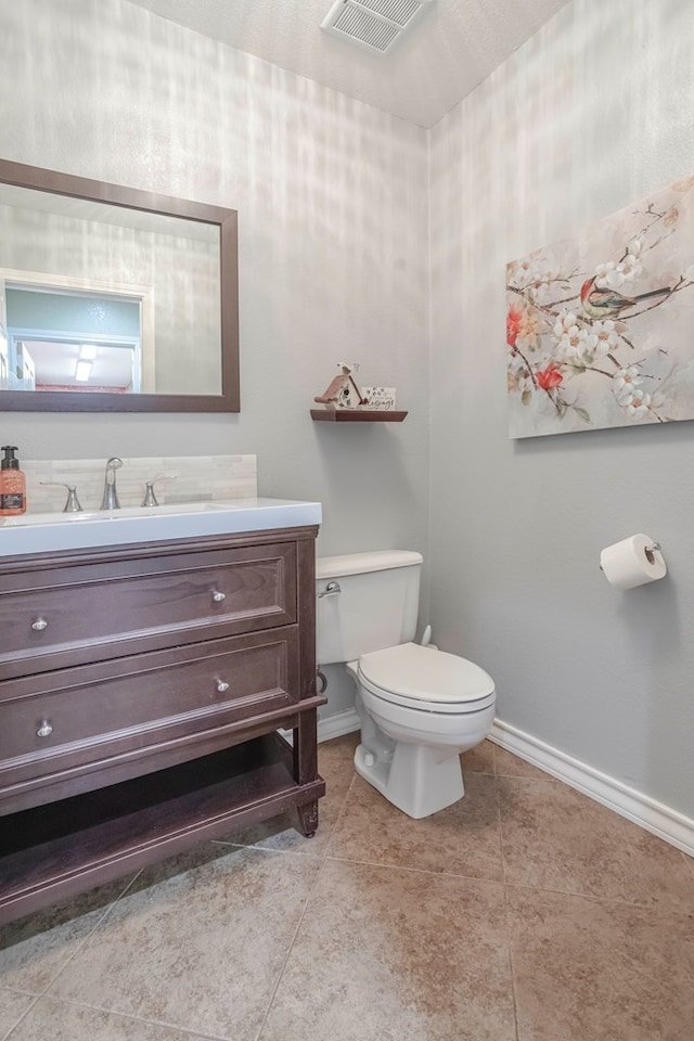 bathroom with vanity, tile patterned flooring, and toilet