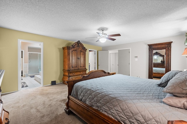 bedroom featuring a textured ceiling, connected bathroom, light colored carpet, and ceiling fan