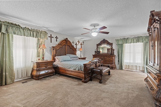 carpeted bedroom with ceiling fan and a textured ceiling