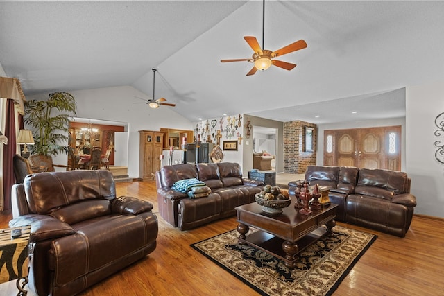 living room featuring a textured ceiling, ceiling fan, light hardwood / wood-style floors, and lofted ceiling