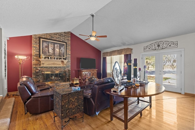 living room with french doors, a textured ceiling, hardwood / wood-style flooring, and lofted ceiling