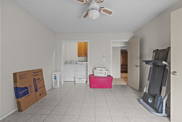 workout area with washing machine and dryer, ceiling fan, light tile patterned floors, and a textured ceiling