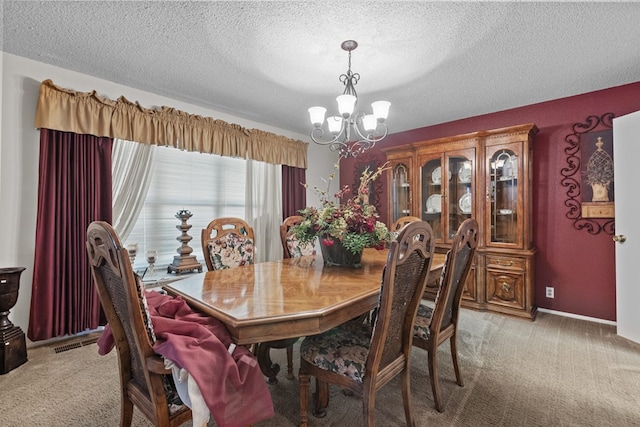 dining space featuring a notable chandelier, light colored carpet, and a textured ceiling