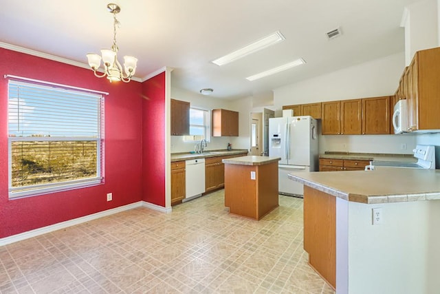 kitchen featuring pendant lighting, sink, white appliances, an inviting chandelier, and a kitchen island