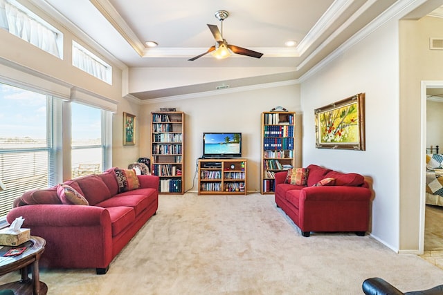 living room featuring a raised ceiling, crown molding, light carpet, and ceiling fan