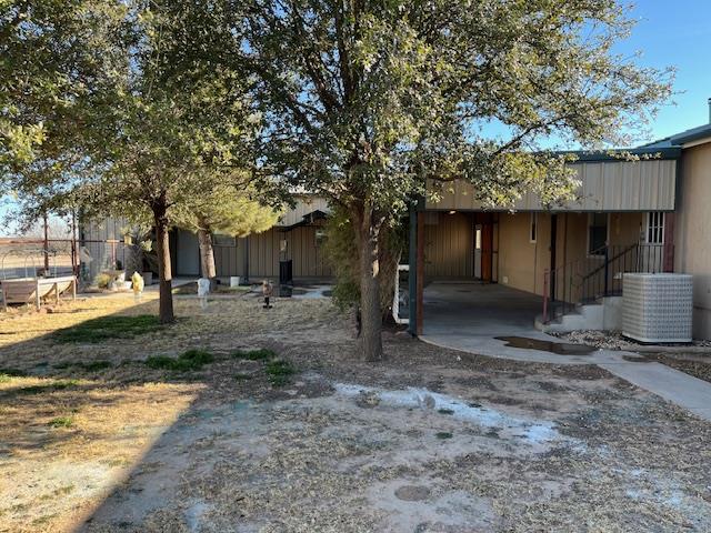 rear view of property featuring a carport and central air condition unit