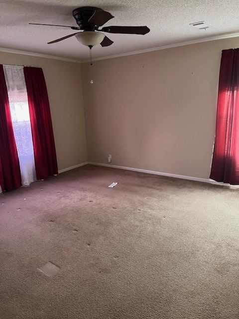 empty room featuring ceiling fan, crown molding, a textured ceiling, and carpet