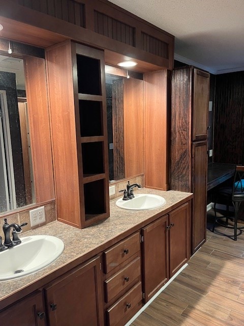 bathroom featuring hardwood / wood-style flooring, vanity, and a textured ceiling