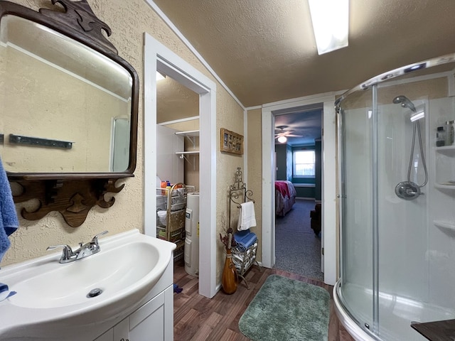 bathroom featuring vaulted ceiling, wood-type flooring, walk in shower, and vanity