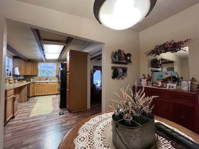 interior space with dishwashing machine, dark wood-type flooring, and black fridge