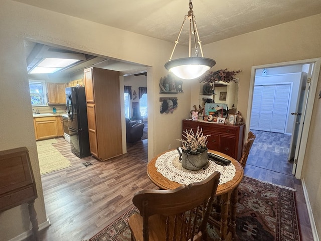 dining space with dark wood-type flooring and sink