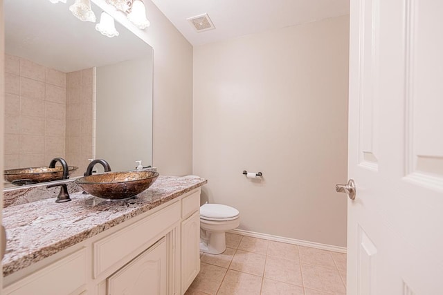 bathroom featuring tile patterned flooring, vanity, and toilet