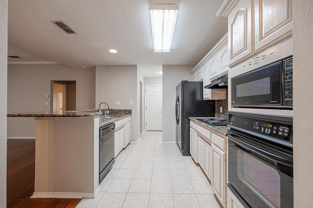 kitchen featuring sink, crown molding, dark stone countertops, light tile patterned floors, and black appliances