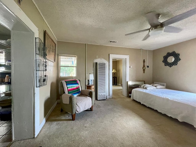 carpeted bedroom featuring ceiling fan and a textured ceiling