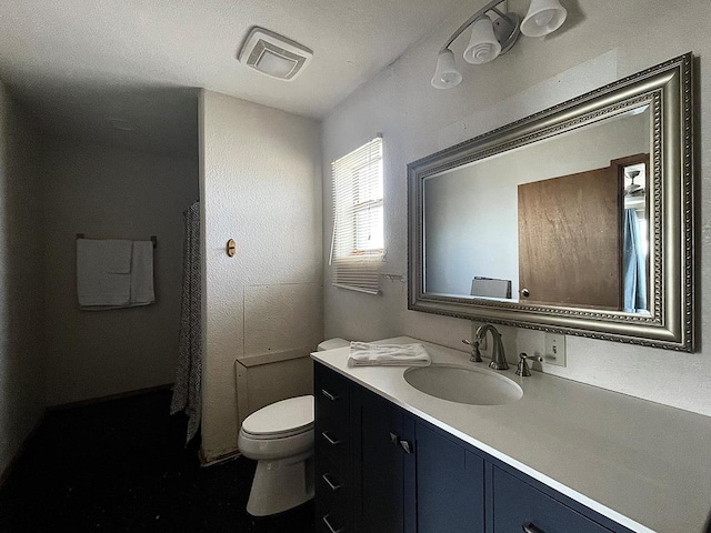 bathroom featuring vanity, toilet, and a textured ceiling