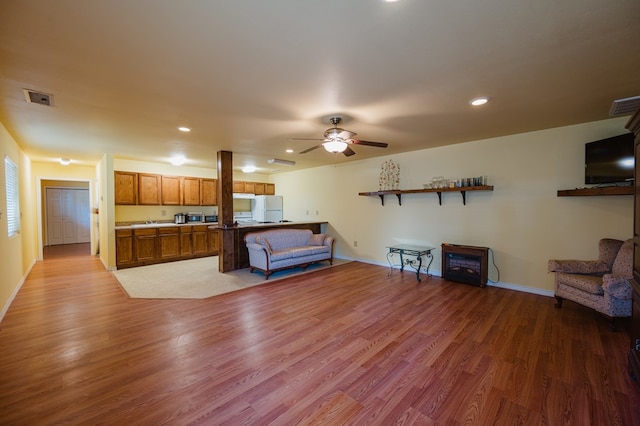 living room featuring ceiling fan and hardwood / wood-style floors